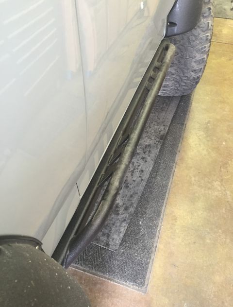 1988 Ford Bronco - Aftermarket rock sliders are installed on the side of a vehicle, with a tire in the background.