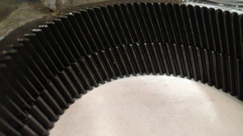 1996 Ford Bronco - A close-up view of a metal gear with numerous teeth, likely a component from a vehicle's drivetrain.
