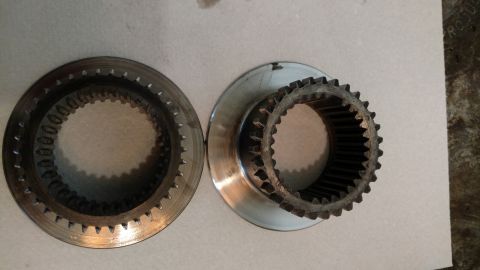 1996 Ford Bronco - Two metal rings with internal teeth are shown. The ring on the left is a solid disc, while the ring on the right is attached to a wider, fl…
