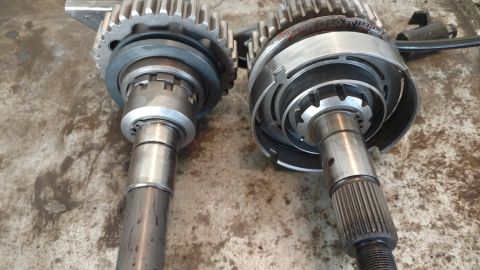 1996 Ford Bronco - Two transmission input shafts are shown in a close-up, side-by-side view. The shaft on the left has a gear and a ring assembly, while the s…