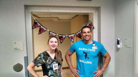 1985 Jeep CJ7 - A man and a woman stand in a hallway decorated with a banner that reads "CONGRATS". The man wears a blue t-shirt with "RADIATION ROLLERS" p…