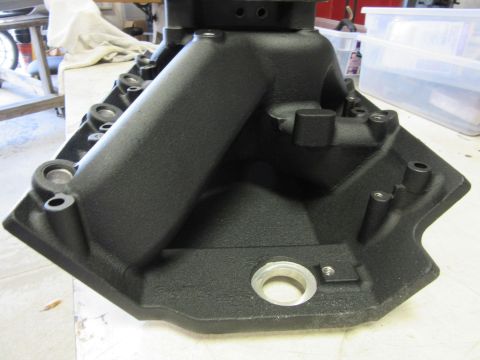 Black textured intake manifold with bolt holes and a silver insert.