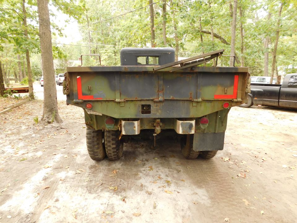 Rear view of a green military truck with red L markings.