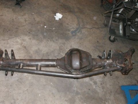 1994 Ford Bronco - A rear axle assembly is shown resting on a concrete floor, with a SuperMotors logo in the corner.