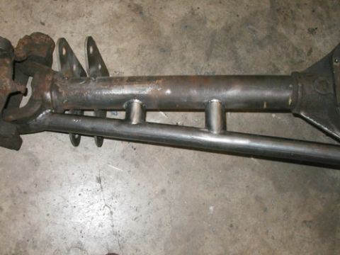 1994 Ford Bronco - Close-up of a front axle assembly with visible welds and metal supports on a concrete surface.