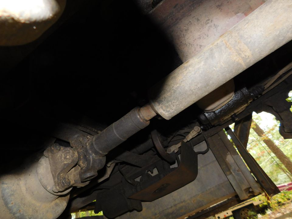 Underside view of a vehicle's driveshaft and universal joint.