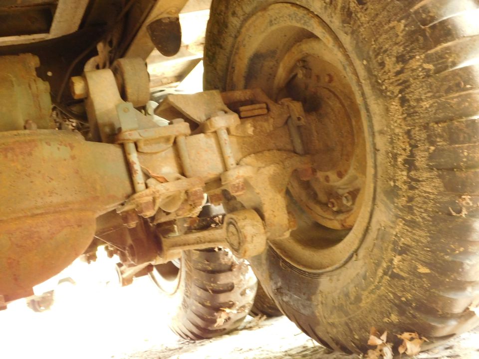 Rear axle and suspension of a heavy-duty vehicle with a large, muddy tire.