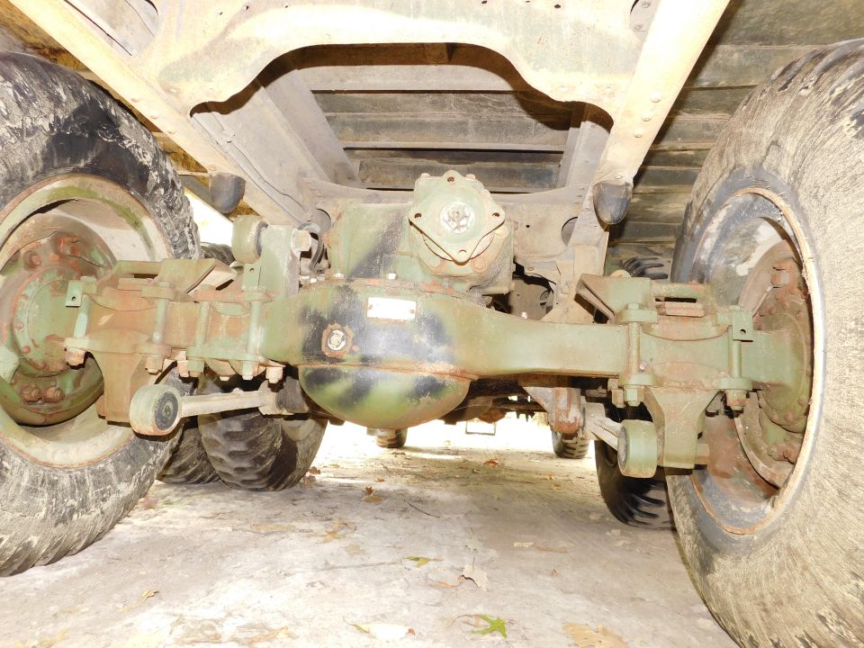 Underside of a vehicle showing rear axle, differential, and tires.