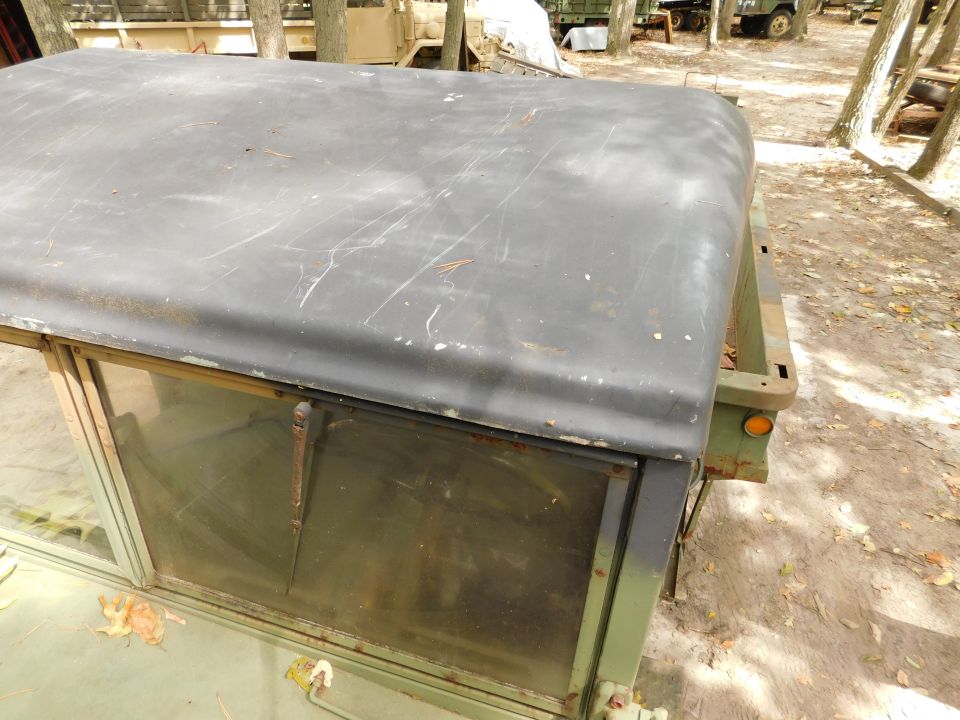 Close-up of the canvas roof and windows of a vintage military vehicle.