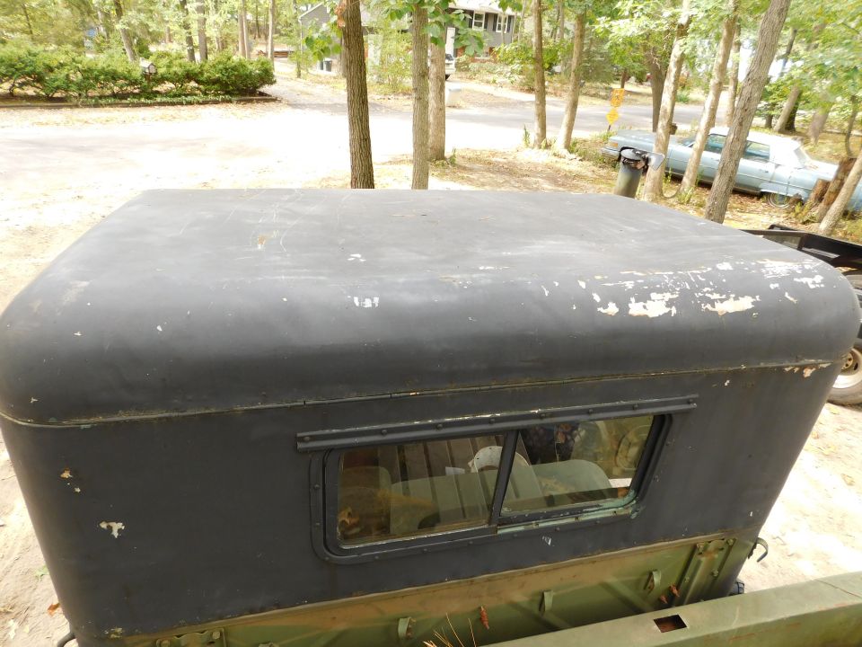 Weathered dark gray vehicle roof with peeling paint and a side window.