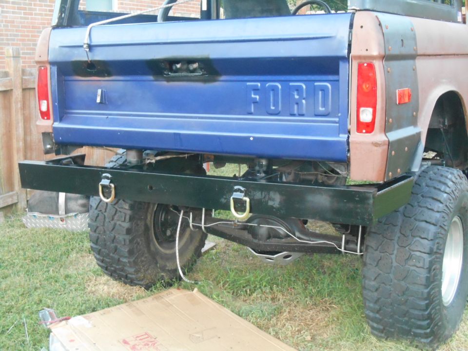 Rear chassis and large tires of a pickup truck, viewed from behind