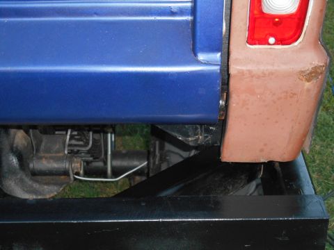 1972 Ford Bronco - Detail shot of the rear of a vehicle, showing the quarter panel, fender, and suspension system.