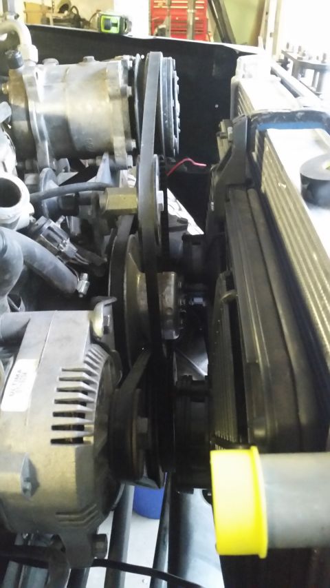 1979 Ford Bronco - Close-up view of the engine bay of a 1979 Ford Bronco, focusing on the serpentine belt system, alternator, and radiator. The components are…