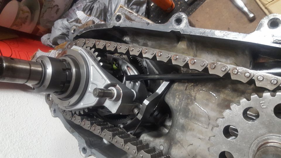 Drive chain, sprockets, and output shaft inside an opened oily transfer case housing on a workbench