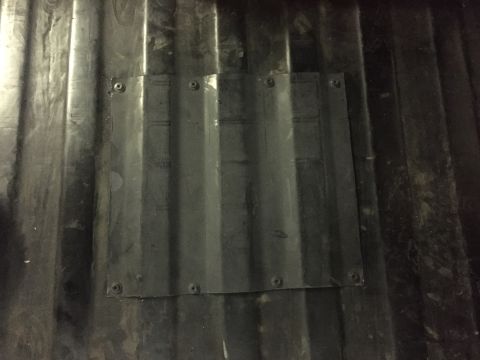 1988 Ford Bronco - A rectangular patch of corrugated plastic is screwed onto the ribbed surface of a dark-colored truck bed or cargo area. The patch appears t…