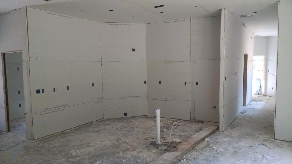 The rest of the house was sheeted Saturday (this is the kitchen), but one spot was covered that shouldn't be.  And the electricians forgot to connect the fireplace, so a little more had to come down. Living room looking east to kitchen.