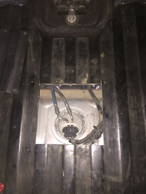 1988 Ford Bronco - A close-up, overhead view shows the fuel pump module assembly installed in a vehicle's fuel tank. The assembly features two fuel lines, a w…