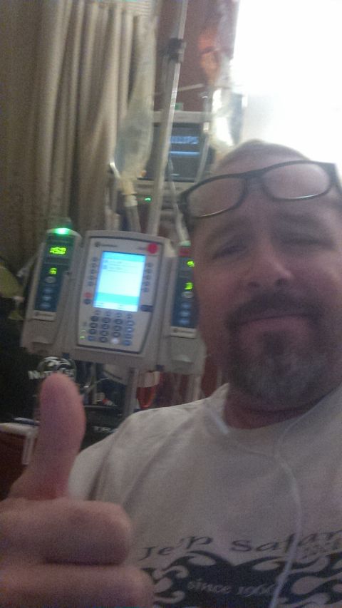 1985 Jeep CJ7 - A man in glasses and a beard gives a thumbs up while in a medical setting with IV pumps and monitors.