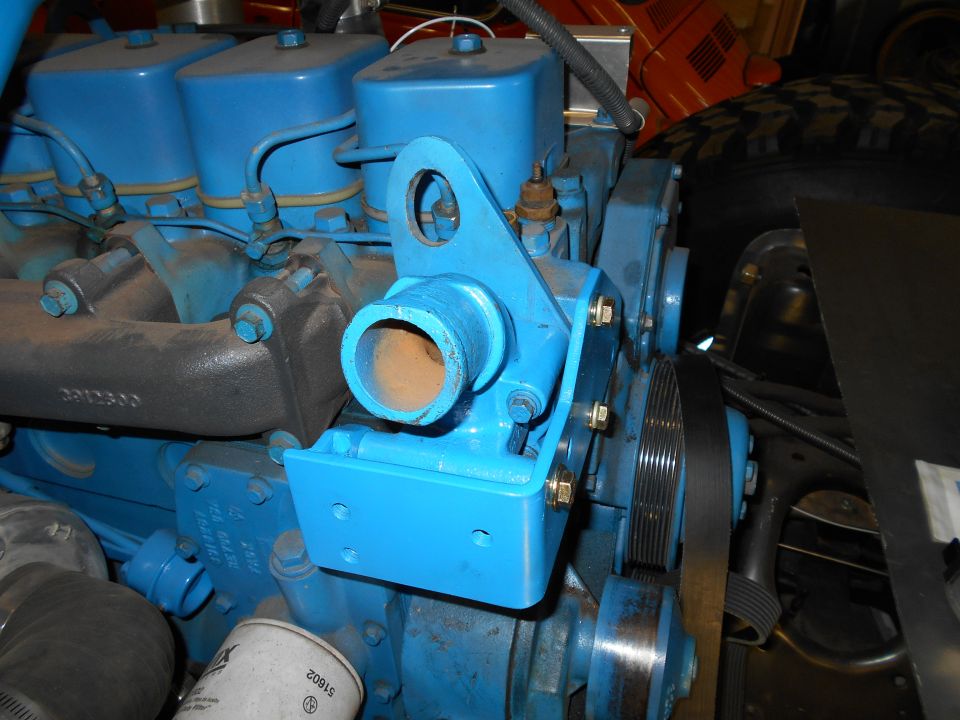 Blue engine block with black serpentine belt and metal components.