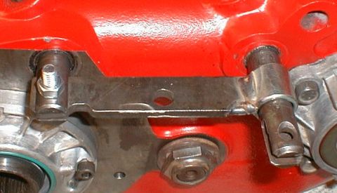 1990 Ford Bronco - Detail of an engine component, showing mechanical assembly with bolts and a bracket.