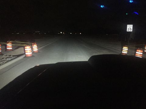 1988 Ford Bronco - View from inside a vehicle at night, showing the road ahead and construction barriers.