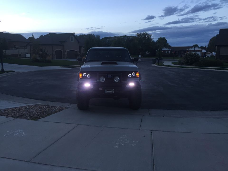 Front view of a dark-colored Ford Bronco with aftermarket lights on