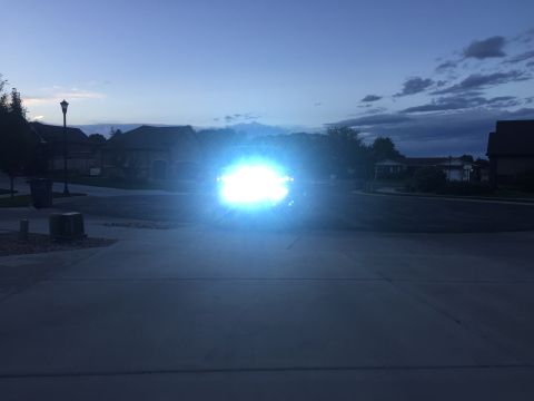 1988 Ford Bronco - The intense glare of headlights dominates this nighttime scene, obscuring the vehicle and its surroundings.