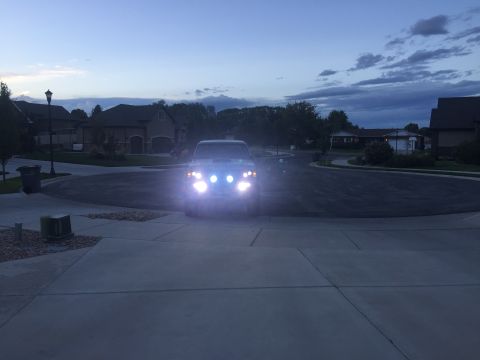 1988 Ford Bronco - Front view of a 1988 Ford Bronco at dusk, headlights illuminated.