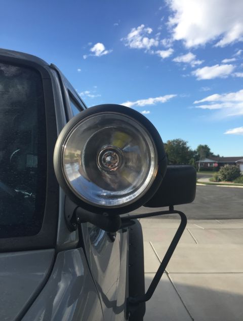 1988 Ford Bronco - A close-up view of a spotlight attached to the fender of a vehicle.