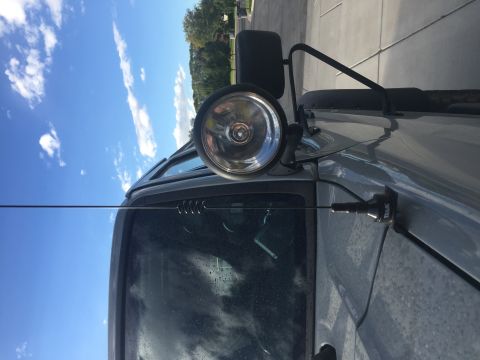1988 Ford Bronco - Close-up of an off-road light attached to a vehicle's fender, with 'TRAIL' visible on the mount.