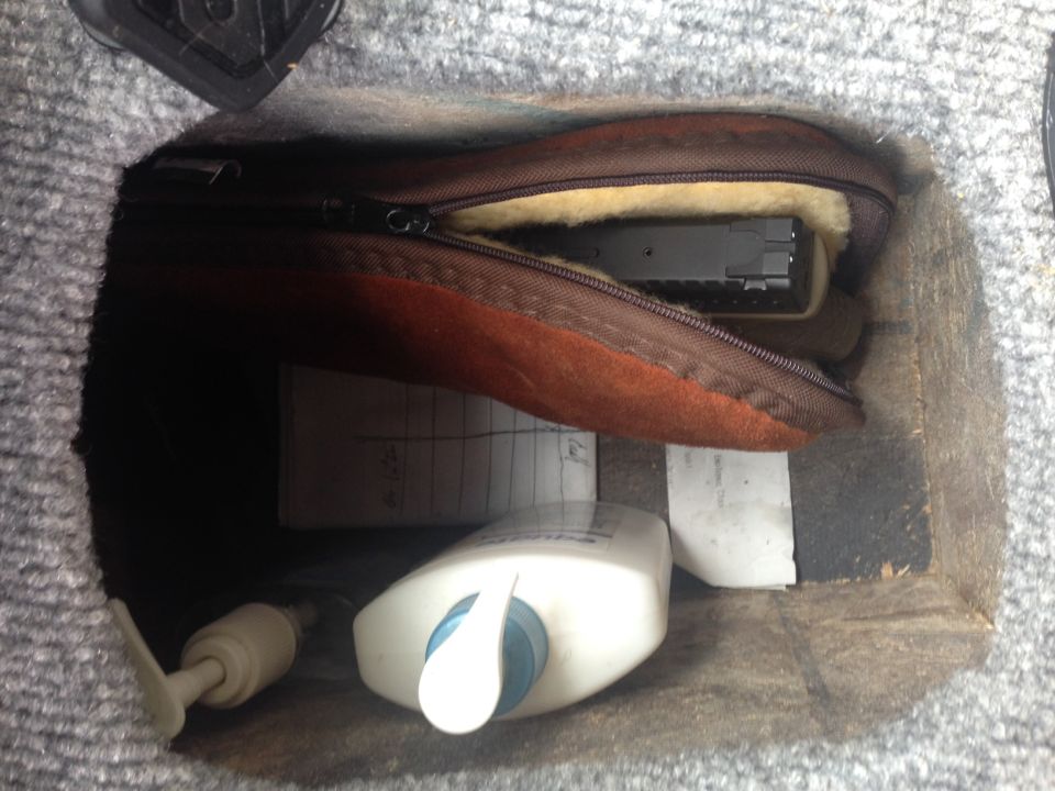 gun in a pouch, lotion bottle, and papers in a compartment