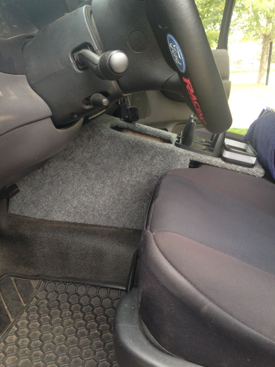 Truck interior floor and seat with Ford Racing logo on transmission tunnel
