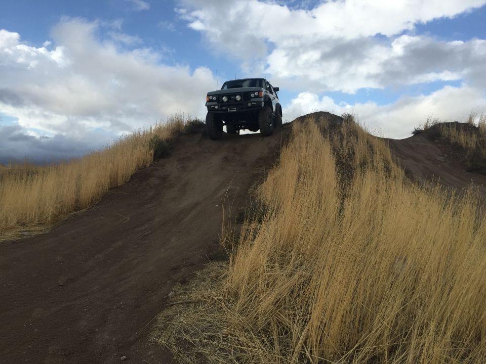 1988 Ford Bronco climbing a dirt hill, 3q-front view