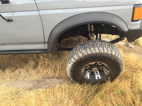 1988 Ford Bronco - This lifted truck features aggressive off-road tires and custom fender flares, suggesting it's built for challenging terrain.