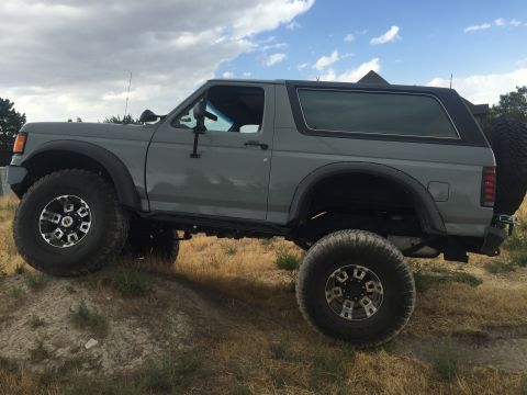 1988 Ford Bronco - This gray Ford Bronco is shown from a three-quarter front angle on a dirt hill.