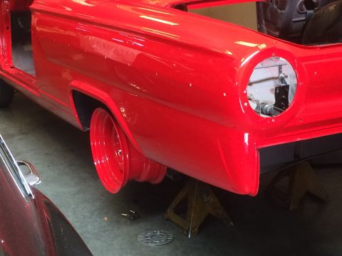 1964 Ford Fairlane - The rear of a red 1964 Ford Fairlane is shown, missing its taillight assembly and resting on jack stands.