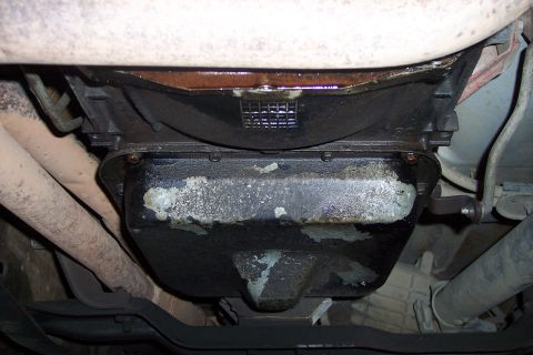 1990 Ford Bronco - Underside view of a vehicle's engine and exhaust system, with visible oil pan and pipes.