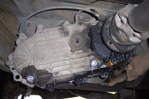 1990 Ford Bronco - Underside view of a vehicle's transfer case and driveshaft, showing signs of oil leakage.