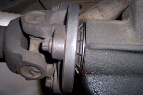 1990 Ford Bronco - Close-up view of a vehicle's driveshaft U-joint and differential flange, with a Supermotors.net watermark visible.