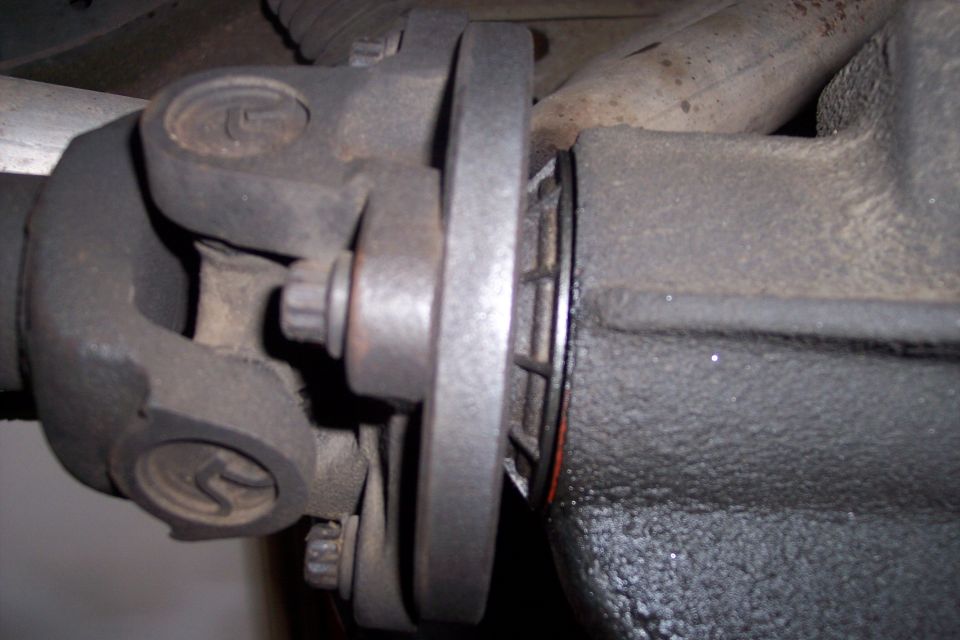 Driveshaft U-joint connected to differential flange with visible Supermotors.net logo