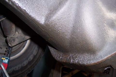 1990 Ford Bronco - Close-up view of the vehicle's undercarriage, with a tire visible on a jack.