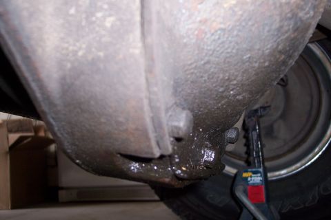 1990 Ford Bronco - Close-up view of a vehicle's undercarriage, focusing on the differential and a tire, with a jack in place.