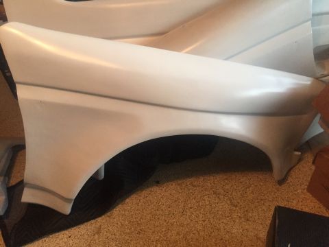 1986 Ford Bronco - A white car fender is shown from the side, with subtle gray trim lines.