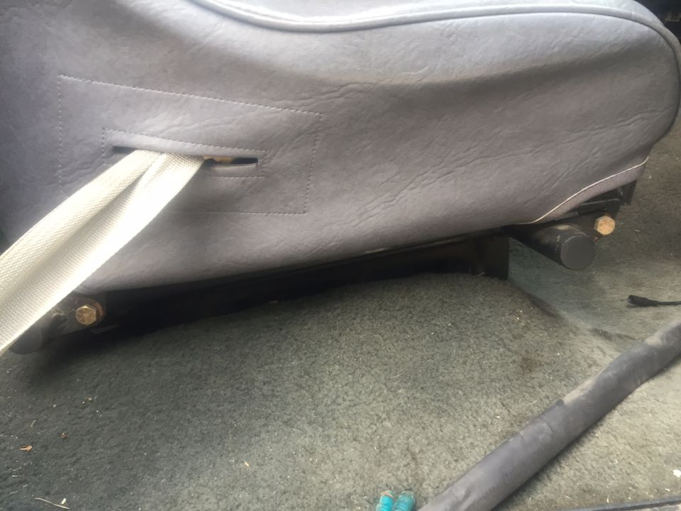 Gray seatbelt emerging from a gray car seat base