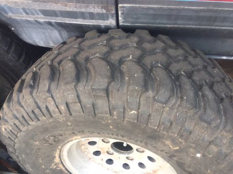1986 Ford Bronco - A close-up view of a off-road tire mounted on a vehicle's wheel.