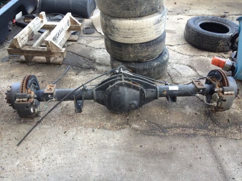 1995 Ford Bronco - A rear axle assembly with disc brakes and differential housing is shown in an outdoor setting.