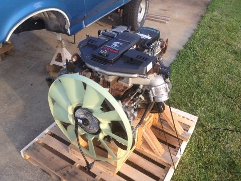1995 Ford Bronco - A Cummins 5.9L turbo diesel engine is displayed on wooden pallets, with a large fan positioned in front.