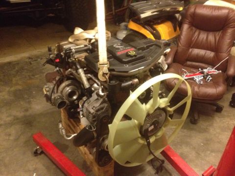 1995 Ford Bronco - A Cummins engine, likely from a Dodge Ram truck, is suspended by straps, ready for installation.