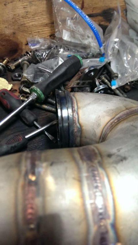 1995 Ford Bronco - A close-up view of a welded exhaust pipe section with tools nearby.