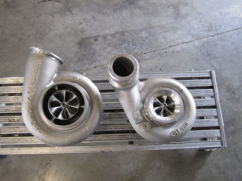 1995 Ford Bronco - Two turbochargers are displayed on a metal grate, with one appearing larger than the other.